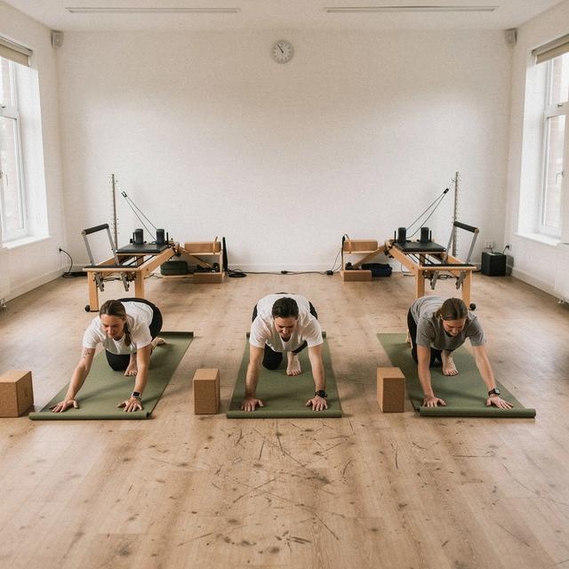 Beginners moving through a slow floor sequence in the studio room